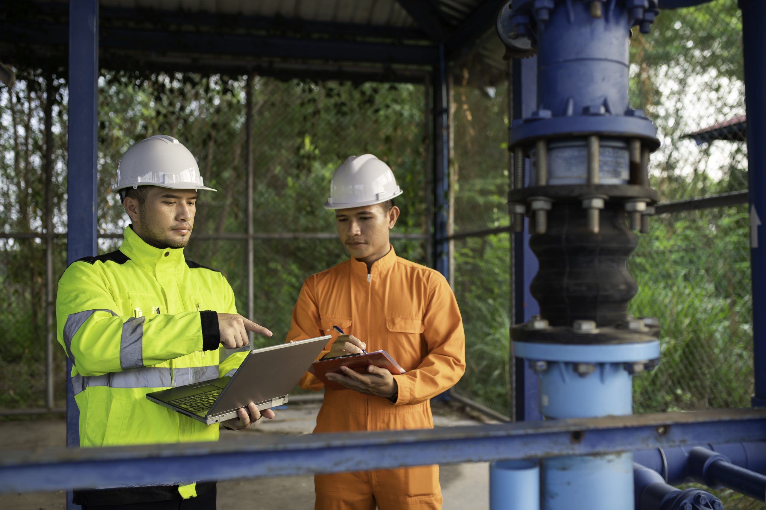 Engineer and technician maintenance checking technical data of system equipment Condenser Water pump and pressure gauge,environmentalist working at water supply